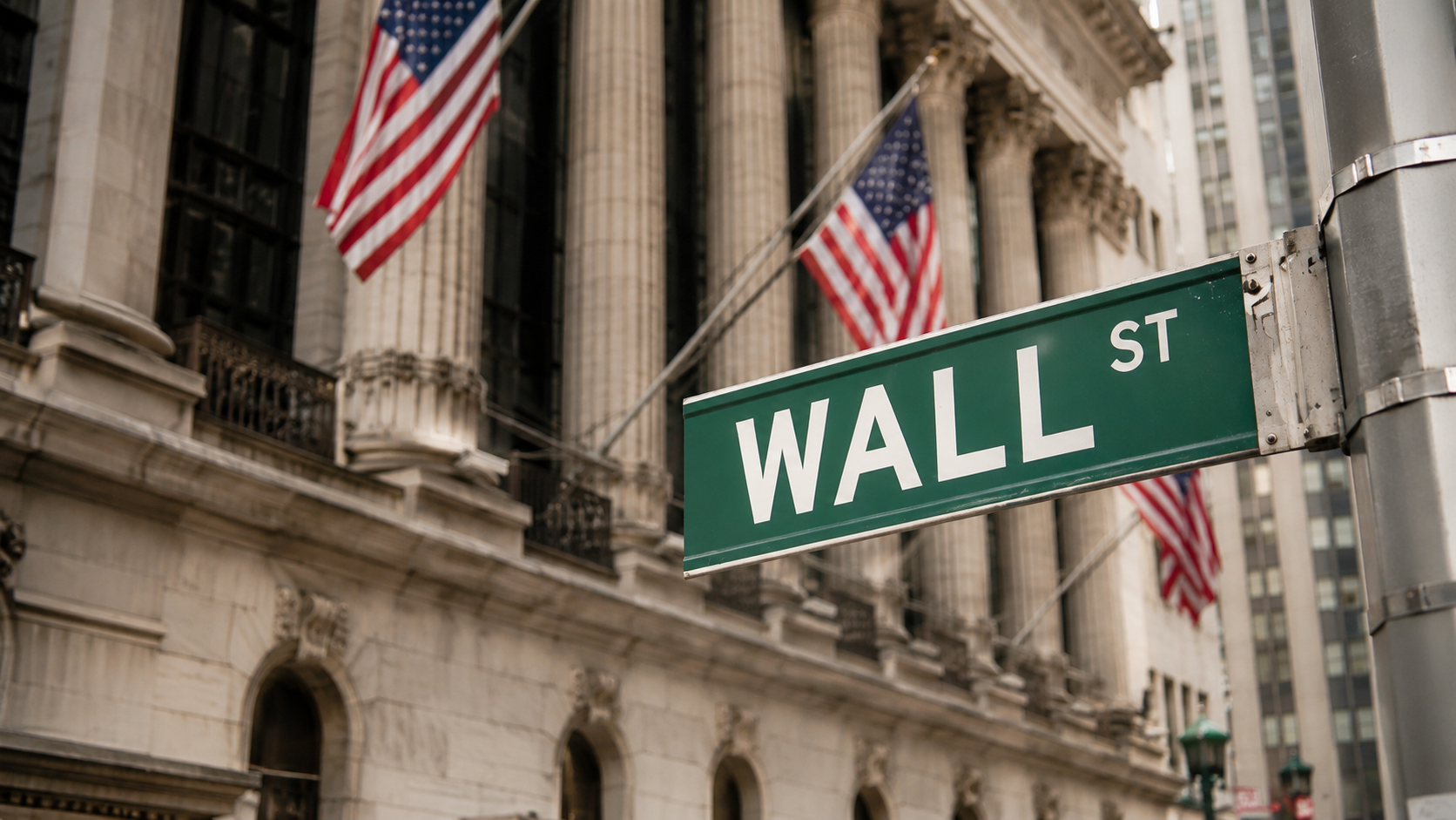 Iconic Wall Street street sign with American flags and stone facade at golden hour