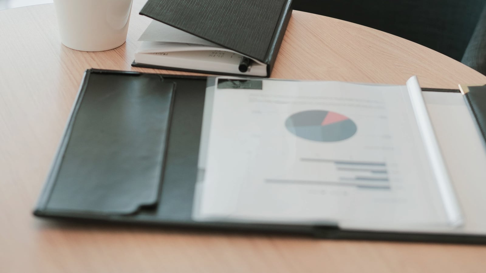 Printed analysis report, notebook, and coffee on an office table